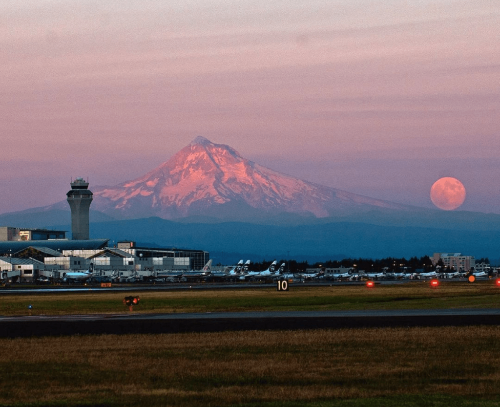 View of PDX and airplanes at sunset, with Mt. Hood in the background.